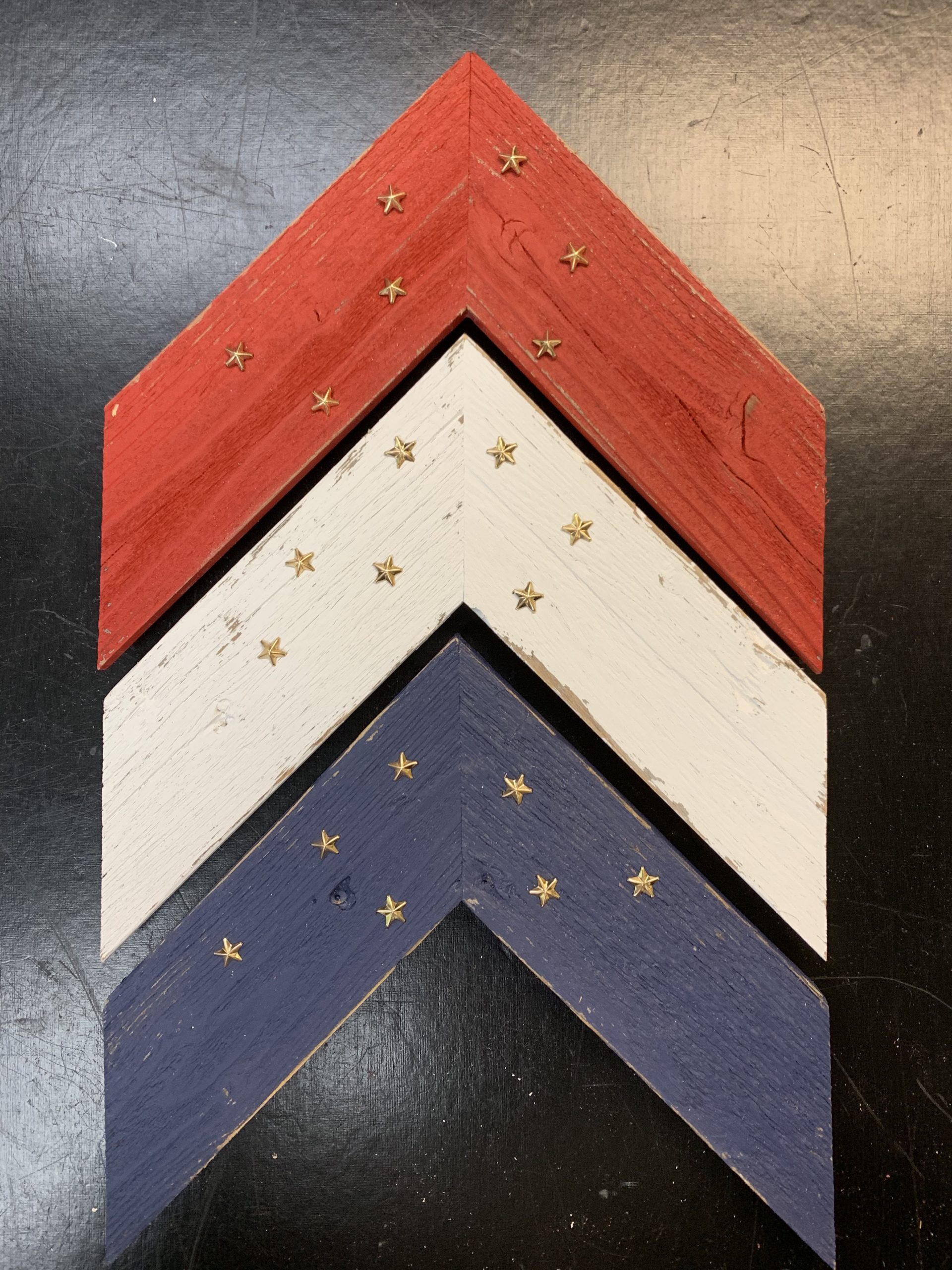 Barnwood painted in Americana colors and decorated with brass stars